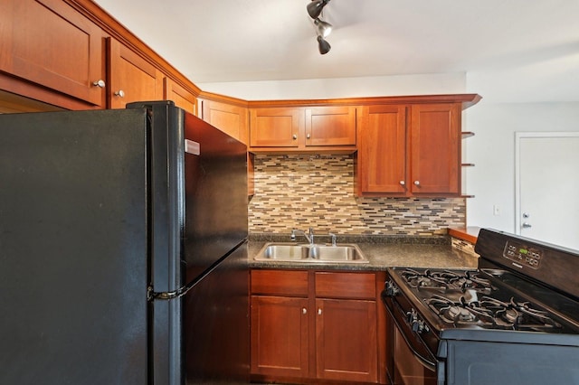 kitchen with black appliances, a sink, dark countertops, tasteful backsplash, and rail lighting