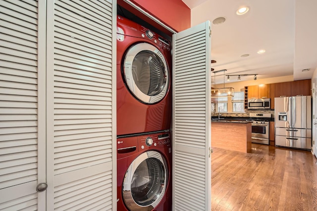 washroom featuring estacked washer and dryer, light wood-style flooring, and recessed lighting