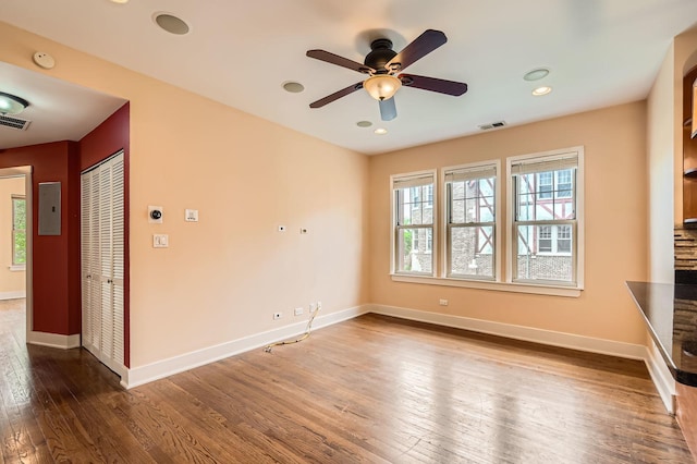 empty room featuring wood finished floors, healthy amount of natural light, baseboards, a ceiling fan, and recessed lighting