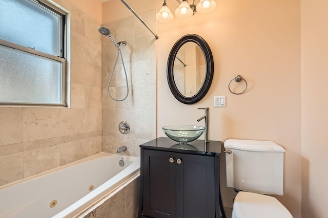 bathroom with plenty of natural light, toilet, a combined bath / shower with jetted tub, and vanity