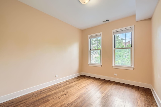 empty room with baseboards and hardwood / wood-style floors