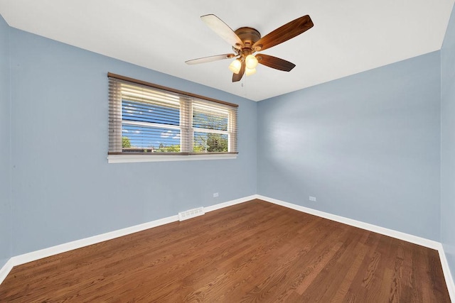 empty room with dark wood-type flooring, baseboards, and ceiling fan
