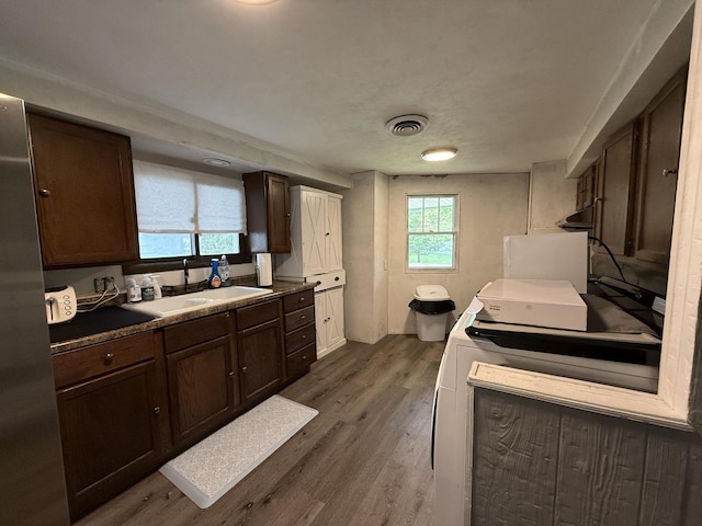 165 N Mill St, Cedarville, IL 61013 - kitchen featuring dark wood-style floors, a sink, dark brown cabinetry, freestanding refrigerator, and under cabinet range hood