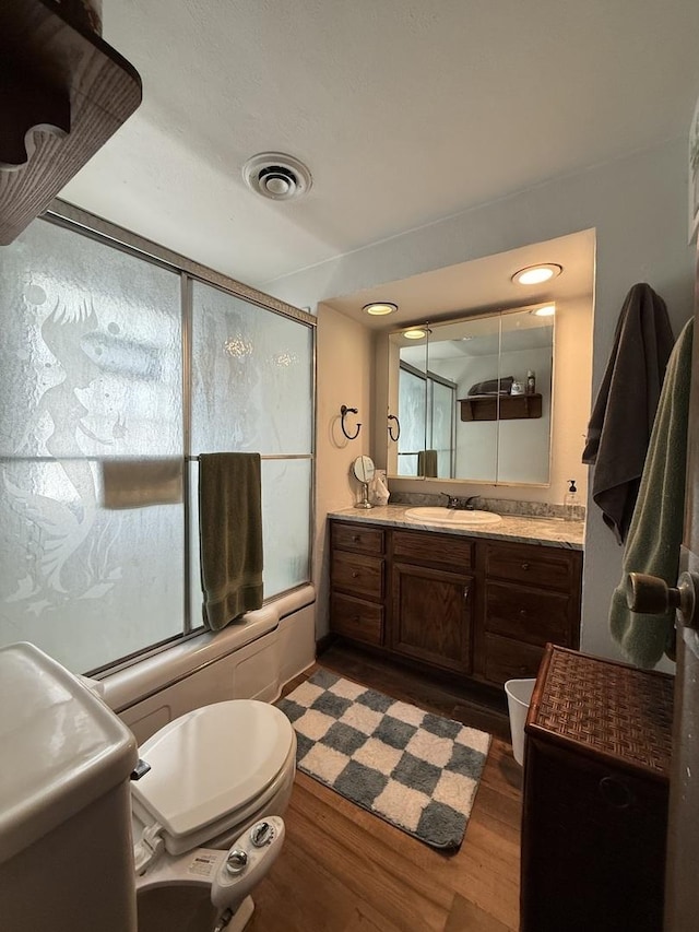 165 N Mill St, Cedarville, IL 61013 - full bathroom with enclosed tub / shower combo, toilet, vanity, and wood finished floors
