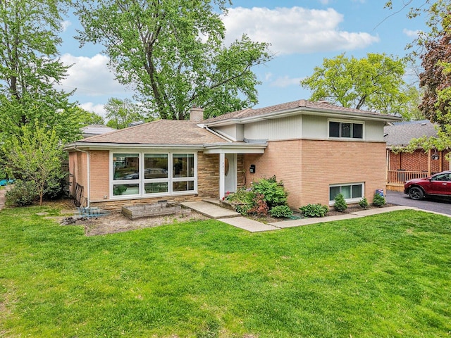9017 Pottawattami Dr, Skokie, IL 60076 - split level home featuring a front yard, a chimney, and brick siding