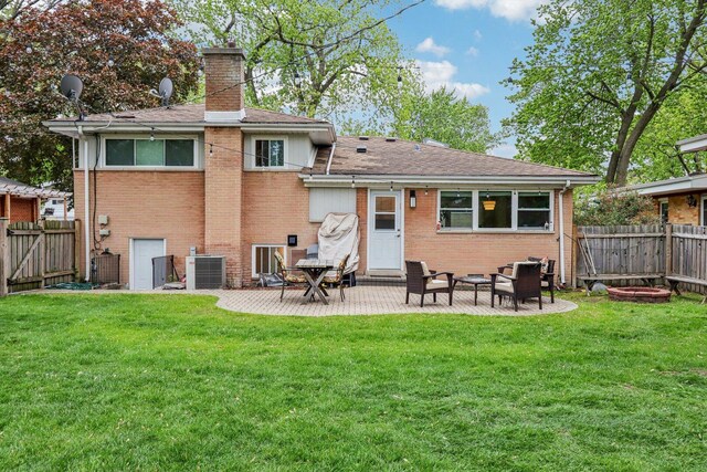9017 Pottawattami Dr, Skokie, IL 60076 - rear view of property with a chimney, brick siding, central AC, a patio area, and a shingled roof
