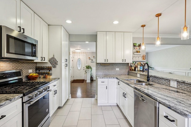 9017 Pottawattami Dr, Skokie, IL 60076 - kitchen featuring appliances with stainless steel finishes, a sink, crown molding, backsplash, and white cabinets