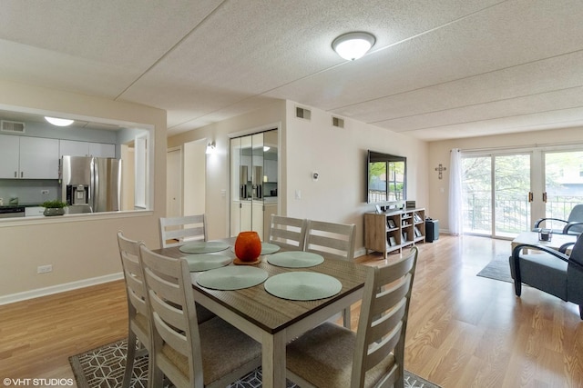 6980 W Touhy Ave Unit 201, Niles, IL 60714 - dining area with light wood finished floors, a textured ceiling, and baseboards