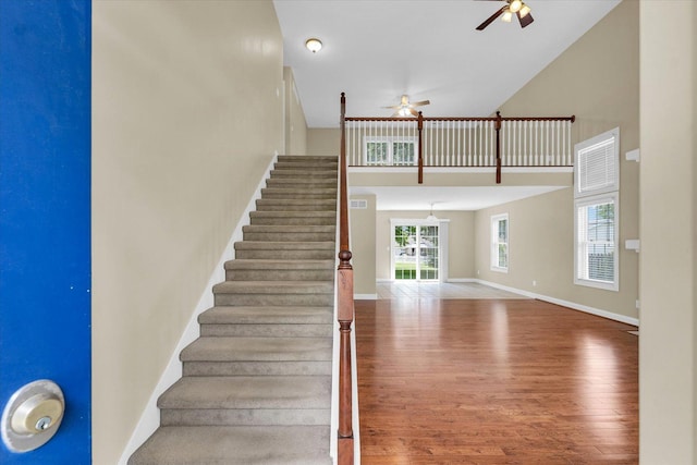 1208 Waters Edge Rd, Champaign, IL 61822 - stairs featuring a ceiling fan, a high ceiling, and wood finished floors