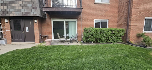 9356 Bay Colony Dr Unit 1S, Des Plaines, IL 60016 - doorway to property featuring a balcony, a lawn, and brick siding