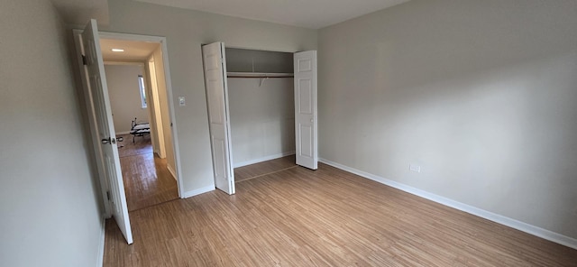9356 Bay Colony Dr Unit 1S, Des Plaines, IL 60016 - unfurnished bedroom featuring wood finished floors, baseboards, and a closet