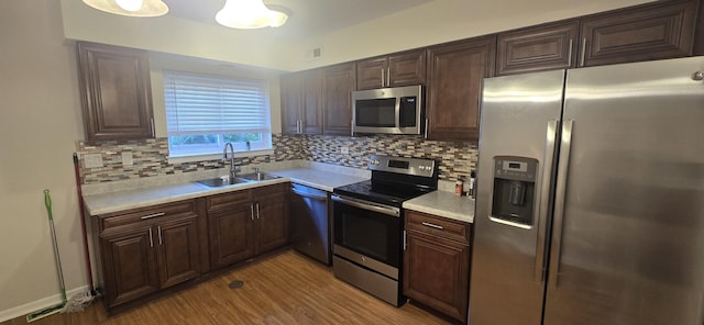 9356 Bay Colony Dr Unit 1S, Des Plaines, IL 60016 - kitchen featuring appliances with stainless steel finishes, a sink, light countertops, light wood-style flooring, and decorative backsplash
