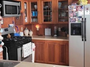 kitchen featuring appliances with stainless steel finishes, brown cabinets, light countertops, and glass insert cabinets