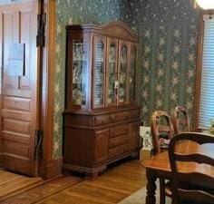 sitting room featuring wallpapered walls and wood finished floors