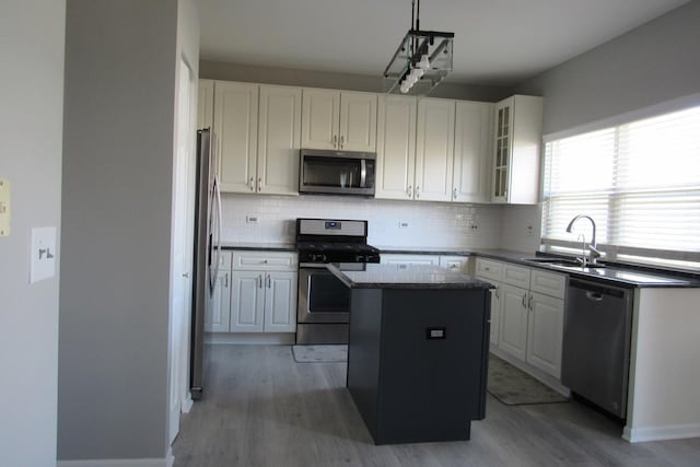 164 Blue Heron Ct, Round Lake, IL 60073 - kitchen featuring stainless steel appliances, a kitchen island, light wood-style floors, a sink, and backsplash