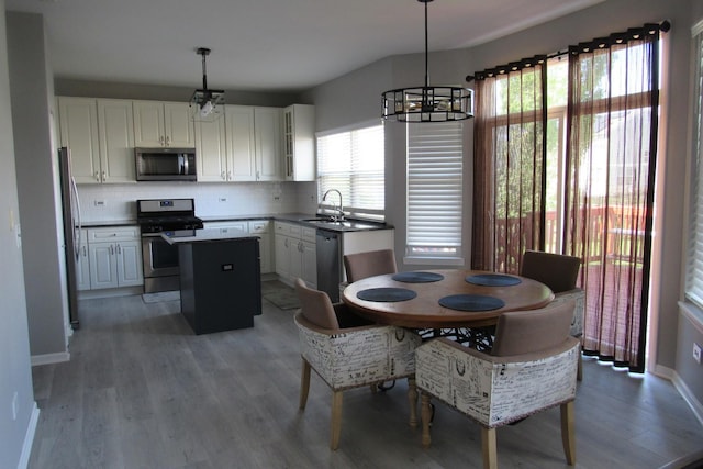 164 Blue Heron Ct, Round Lake, IL 60073 - dining space with a chandelier, light wood-style floors, and baseboards