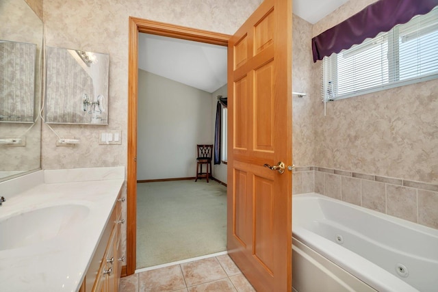 bathroom featuring a whirlpool tub, vanity, tile patterned floors, lofted ceiling, and baseboards