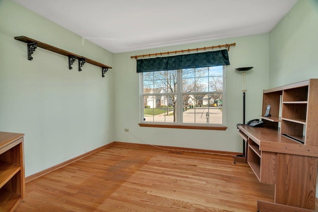 unfurnished office featuring light wood-style flooring and baseboards