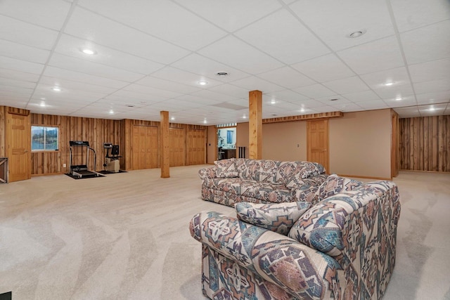 living area featuring light carpet, wood walls, a paneled ceiling, and recessed lighting