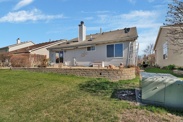 rear view of house with a yard, a chimney, and a patio area