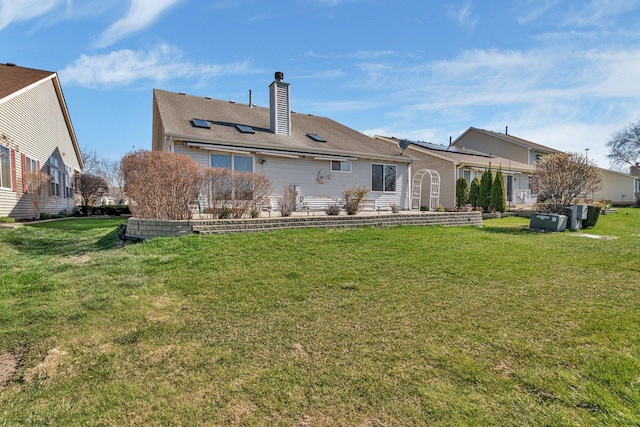 back of property with a yard and a chimney