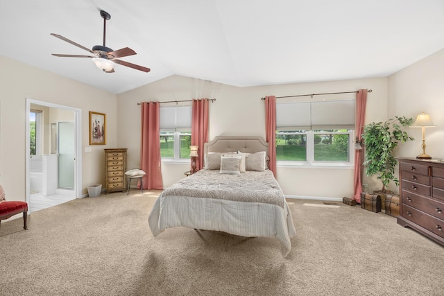 carpeted bedroom featuring lofted ceiling, ensuite bath, ceiling fan, and baseboards