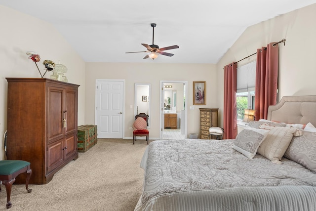 bedroom with light carpet, lofted ceiling, baseboards, ceiling fan, and ensuite bathroom