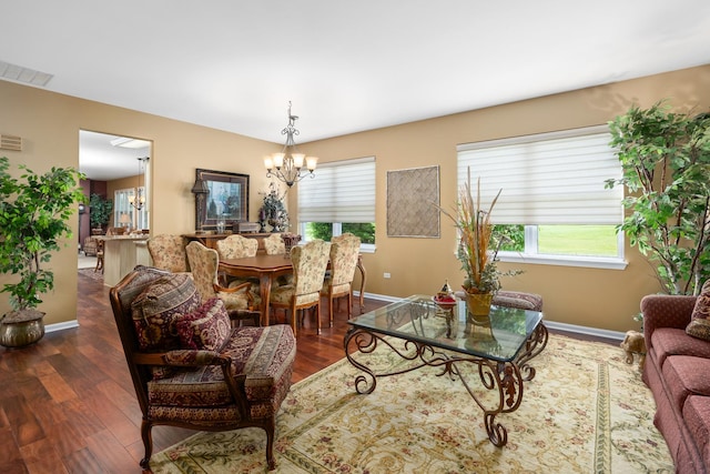 living room with a chandelier, baseboards, dark wood-style floors, and healthy amount of natural light