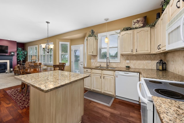 kitchen featuring white appliances, a sink, open floor plan, and dark wood-type flooring