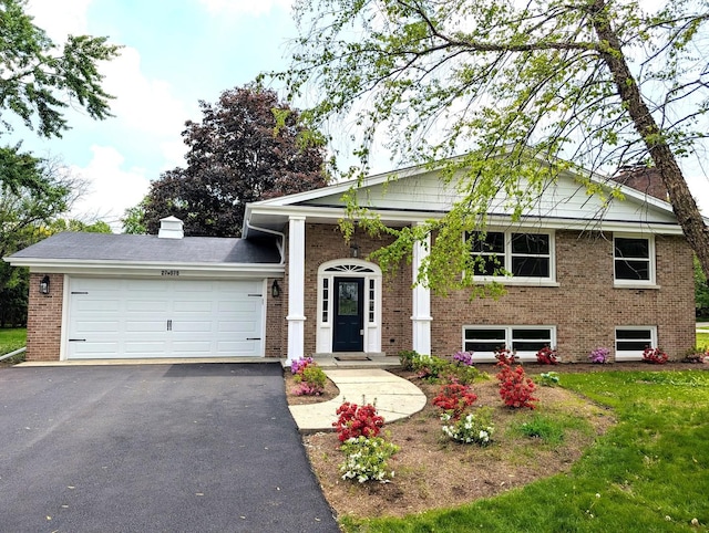 27W075 Fleming Dr, Winfield, IL 60190 - view of front facade featuring brick siding, an attached garage, driveway, and a front yard