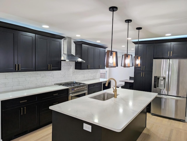 27W075 Fleming Dr, Winfield, IL 60190 - kitchen featuring stainless steel appliances, wall chimney range hood, a sink, dark cabinetry, and light wood-type flooring