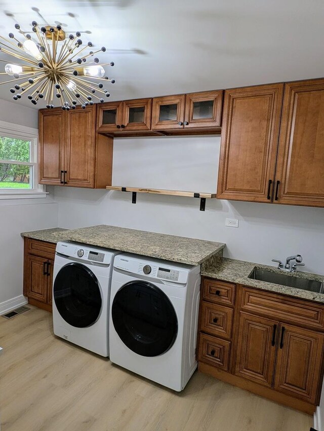 27W075 Fleming Dr, Winfield, IL 60190 - laundry room featuring washer and clothes dryer, cabinet space, light wood finished floors, and a chandelier