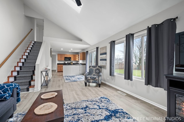 327 Persimmon Ln, Oswego, IL 60543 - living area featuring healthy amount of natural light, light wood-style flooring, baseboards, stairway, and high vaulted ceiling