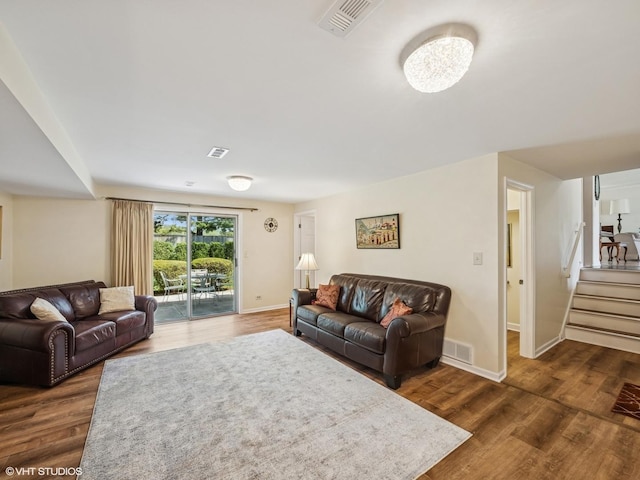 living area featuring dark wood finished floors, stairs, and baseboards