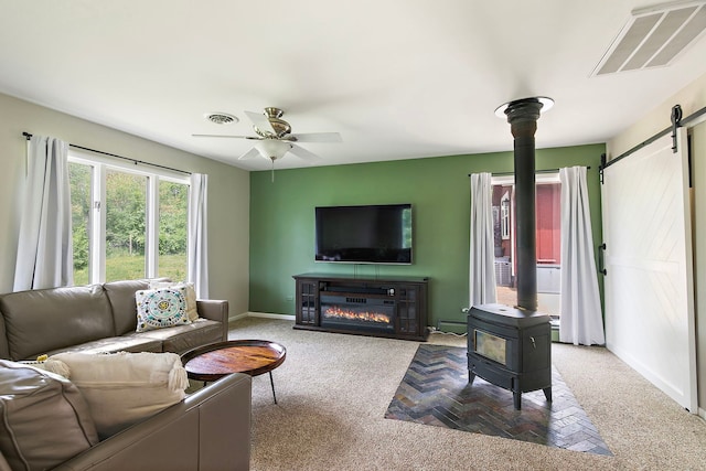 543 Blackhawk Dr, Lake In The Hills, IL 60156 - living room with a wood stove, a barn door, carpet flooring, ceiling fan, and baseboard heating