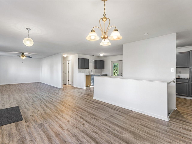1659 Larchmont Rd, Davis, IL 61019 - unfurnished living room featuring light wood-style floors, a chandelier, ceiling fan, and baseboards