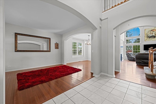 343 Diane Ct, Geneva, IL 60134 - entrance foyer featuring arched walkways, light wood finished floors, a chandelier, and baseboards