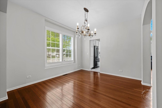 343 Diane Ct, Geneva, IL 60134 - unfurnished dining area with hardwood / wood-style flooring, a chandelier, baseboards, and arched walkways