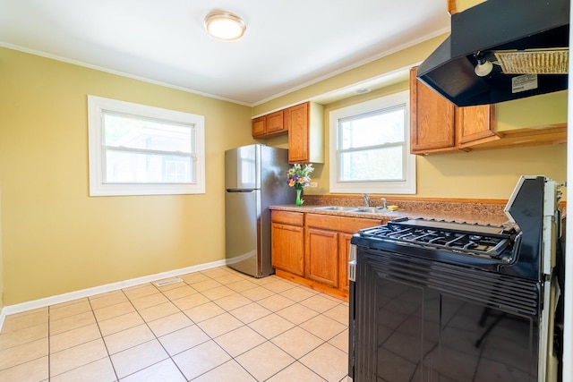 kitchen with freestanding refrigerator, black gas range, under cabinet range hood, ornamental molding, and a sink