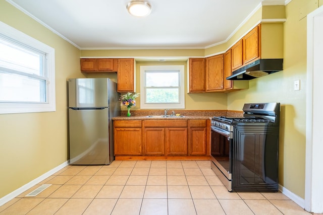 kitchen with appliances with stainless steel finishes, under cabinet range hood, brown cabinets, a sink, and crown molding