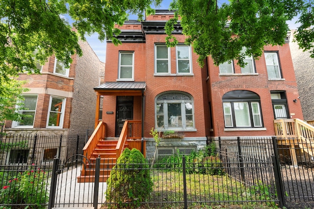 3230 W Fulton Blvd, Chicago, IL 60624 - view of front of property with brick siding, a fenced front yard, and a standing seam roof