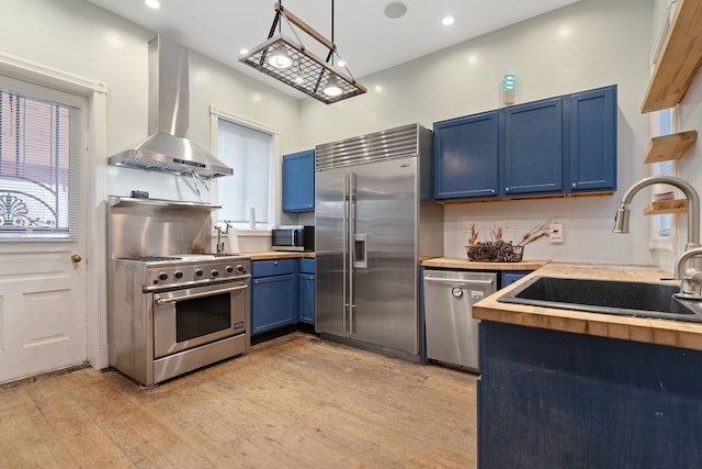 3230 W Fulton Blvd, Chicago, IL 60624 - kitchen with premium appliances, island range hood, blue cabinets, a sink, and light wood-style flooring