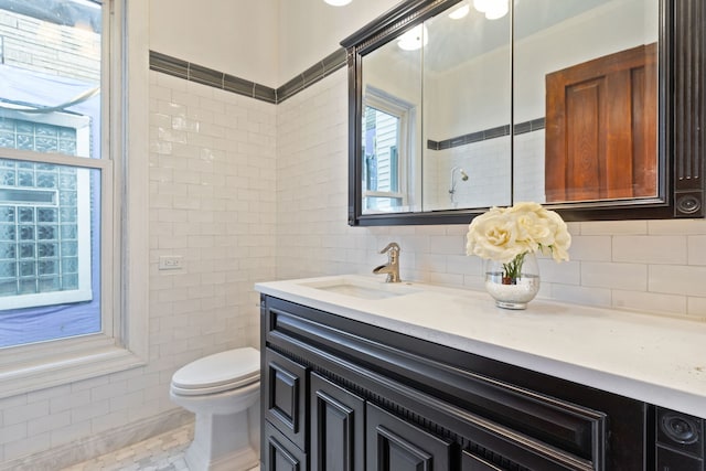 3230 W Fulton Blvd, Chicago, IL 60624 - bathroom with vanity, toilet, tile walls, and decorative backsplash