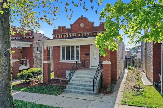 view of front of property featuring brick siding and fence