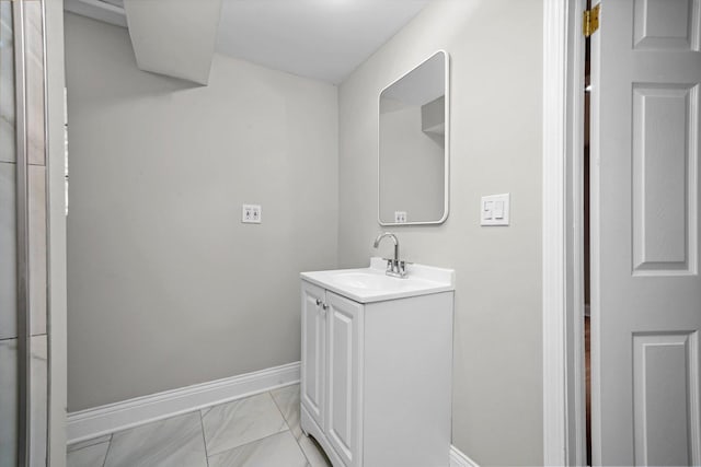 bathroom featuring baseboards, vanity, and marble finish floors
