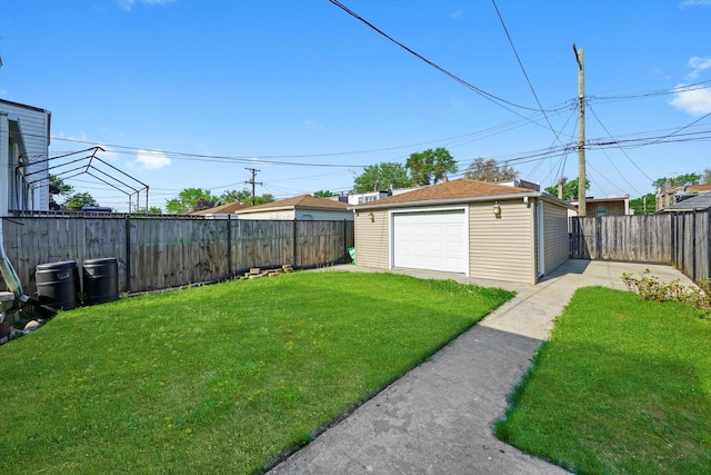 view of yard with a garage, an outbuilding, and driveway