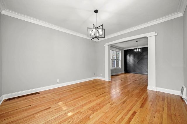 unfurnished room with a chandelier, baseboards, ornamental molding, and light wood finished floors