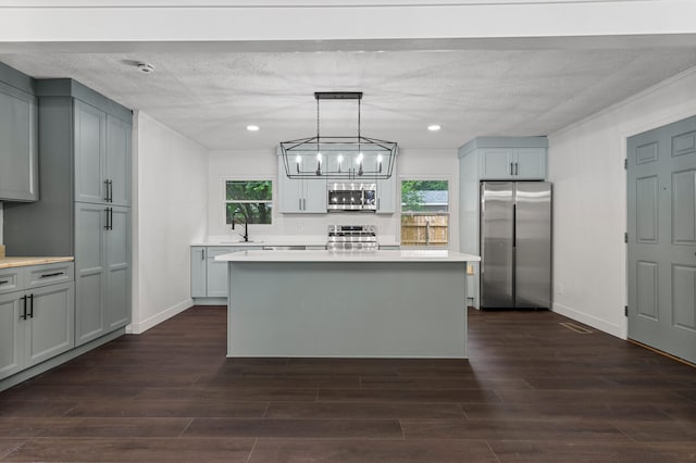 1802 Meadow Dr, Champaign, IL 61821 - kitchen featuring appliances with stainless steel finishes, a kitchen island, light countertops, dark wood finished floors, and recessed lighting