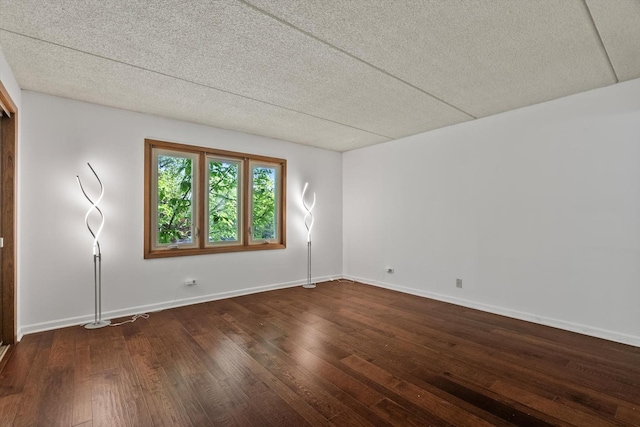 spare room featuring wood finished floors, baseboards, and a textured ceiling