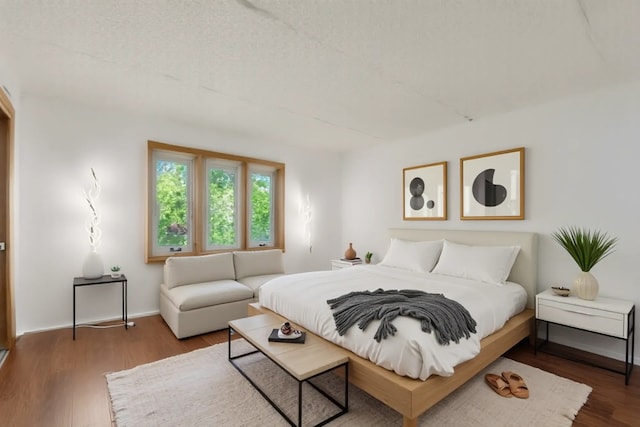 bedroom with wood finished floors and baseboards